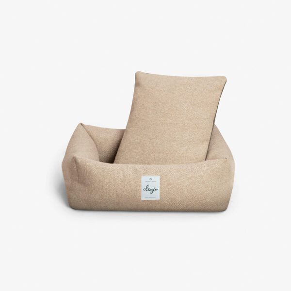 Rektangulär hundbädd med textiletikett framtill. I hundbädden står en rektangulär kudde i samma textil.